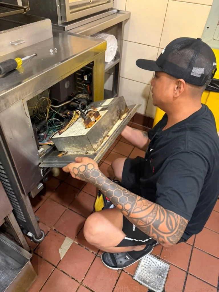 Technician servicing commercial kitchen equipment